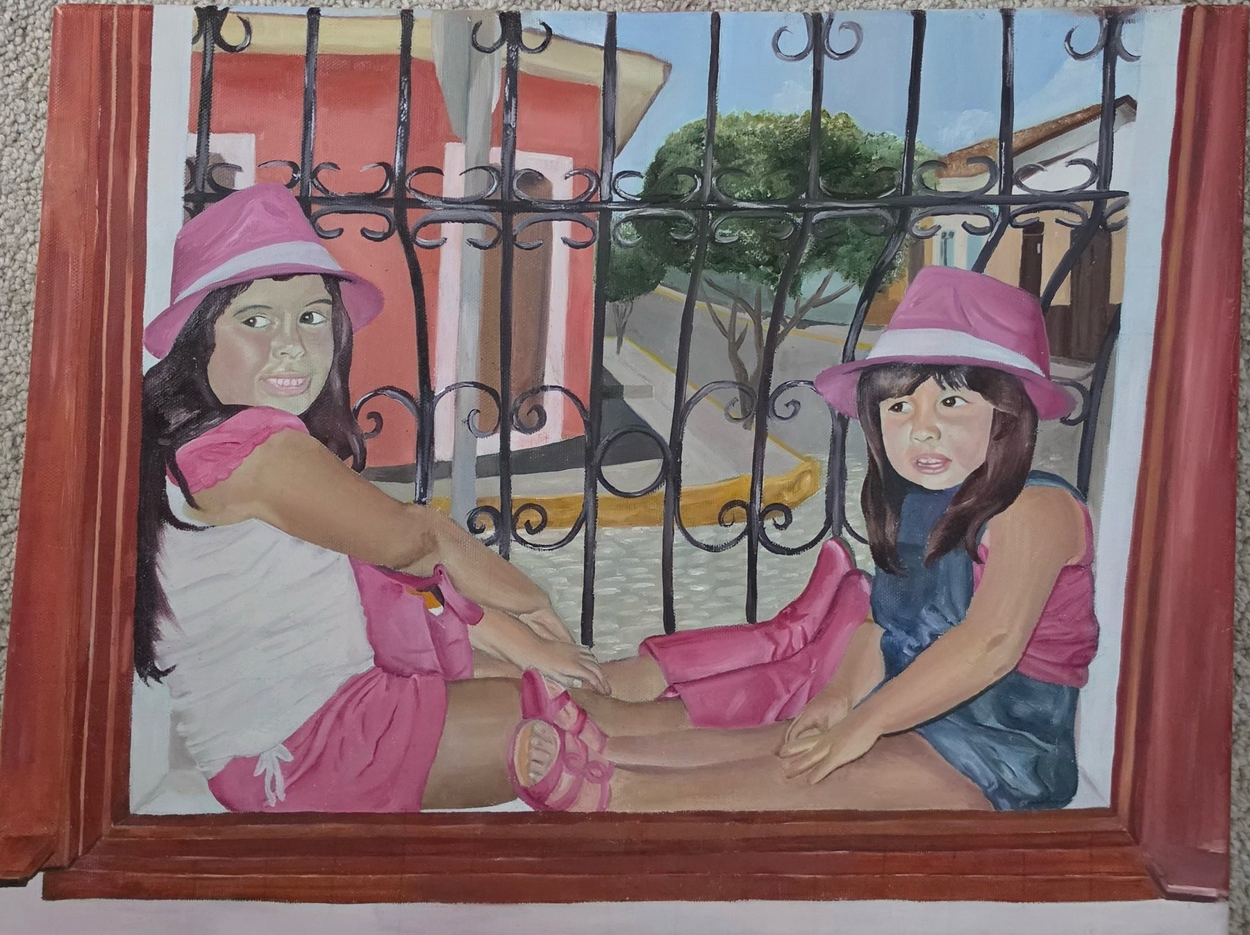 Painting of two young girls in pink hats sitting behind a wrought-iron balcony railing above a sunny street.